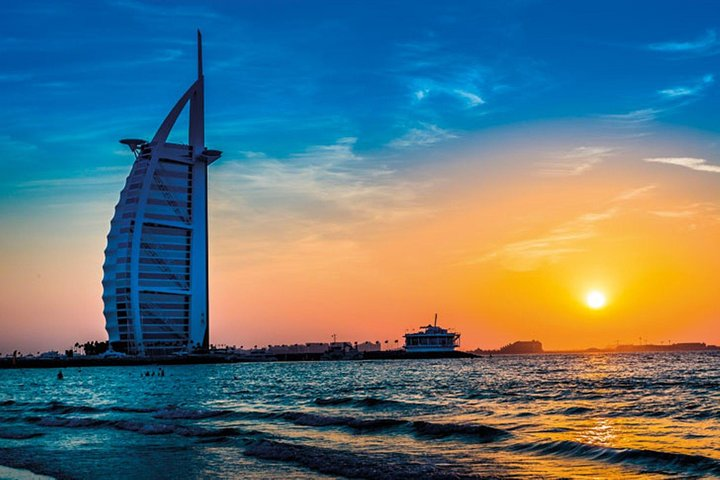 Experience Dubai's stunning skyline as the sun sets behind the iconic Burj Al Arab blending modern architecture with a serene coastal view perfect for an unforgettable exploration.